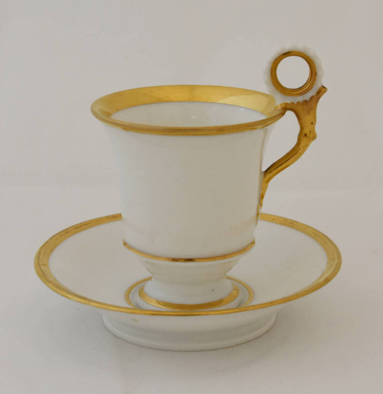 Cup and saucer in white with gold trim. 